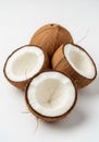 Three opened coconuts and one whole coconut arranged on a white background. The Royalty Free Stock Photo