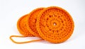 Three Orange Crochet Coasters Stacked on White Background with One Strand Connected Royalty Free Stock Photo
