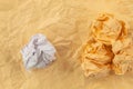 Three orange crumpled papers and one white paper lie on an orange paper background