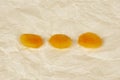 Three orange dried apricots lie on crumpled paper in a row Royalty Free Stock Photo