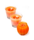 Three orange handmade candles, isolated on white