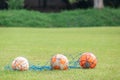 Three old soccer balls on a green grass training pitch Royalty Free Stock Photo