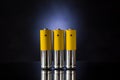 Three orange rechargeable batteries on a blue backlit background