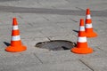 Three orange traffic cones used to mark off area with the damaged manhole cover