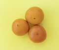 Three oranges stand out next to each other on a yellow background