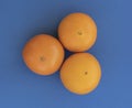 Three oranges stand out next to each other on a blue background