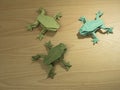 Three Origami Frog on wooden background Royalty Free Stock Photo