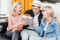 Cheerful group of friends eating popcorn at home Royalty Free Stock Photo