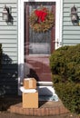 Three packages delivered to front door with Christmas wreath in December