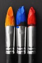 Three paint brushes with different colors of paints on them, AI