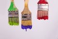 Three paint brushes dripping wet paint red purple and green paint Royalty Free Stock Photo