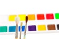 Three paintbrushes against various paints