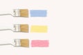 Three paintbrushes with pastel colored painting trace on a white background Royalty Free Stock Photo