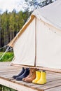 Three pair of shoes near bell tent Royalty Free Stock Photo