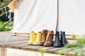 Three pair of shoes on wooden terrace behind a canvas tent
