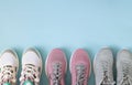 Three pair of sport shoes top view on light blue background