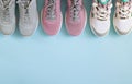 Three pair of sport shoes top view on light blue background with copy space