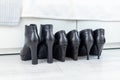 three pairs of black boots with high heels in front of a white closet Royalty Free Stock Photo