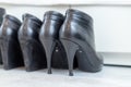 three pairs of black boots with high heels in front of a white closet Royalty Free Stock Photo