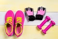 Three pairs of different fitness sports things on a wooden striped background