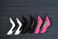 Three pairs of different high heel shoes. Black wooden background Royalty Free Stock Photo