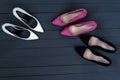 Three pairs of different high heel shoes. Black wooden background Royalty Free Stock Photo