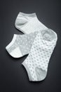 Three pairs of female gray socks: striped, polka dots and hearts on a black background, vertically