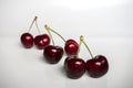 Three pairs of sweet red cherries arranged in a row on a white background. Food and drink concept Royalty Free Stock Photo