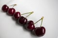 Three pairs of sweet red cherries arranged in a row on a white background. Food and drink concept Royalty Free Stock Photo