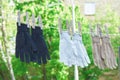 Three pairs of textile gloves hanging on clothesline outdoors