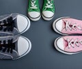 Three pairs of textile worn sneakers on a black background