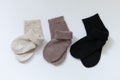Three pairs of warm socks on a white background, white, brown, black Royalty Free Stock Photo