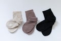 Three pairs of warm socks on a white background, white, brown, black Royalty Free Stock Photo