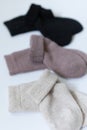 Three pairs of warm socks on a white background, white, brown, black Royalty Free Stock Photo