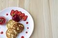 Three pancakes with cheese and strawberries and sauce on a white dish against wood background. Delicious cheese pancake and Royalty Free Stock Photo