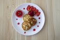 Three pancakes with cheese and strawberries and sauce on a white dish against wood background. Delicious cheese pancake and Royalty Free Stock Photo