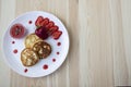 Three pancakes with cheese and strawberries and sauce on a white dish against wood background. Delicious cheese pancake and Royalty Free Stock Photo