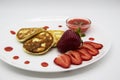 Three pancakes with cheese and strawberries and sauce on a white dish against wood background. Delicious cheese pancake and Royalty Free Stock Photo