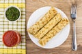 Three pancakes with stuffing in plate, fork , tomato juice Royalty Free Stock Photo