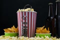 Three paper cups of food and two bottles of beer for watching movies Royalty Free Stock Photo