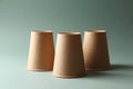 Three paper cups on pale olive background. Thimblerig game Royalty Free Stock Photo