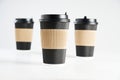 Three paper disposable coffee black cup for take away or to go, isolated on white, space for design layout