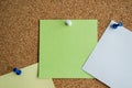 Three paper notes green, white and yellow color on a cork Board, attached with a white pushpin. Copy space Royalty Free Stock Photo