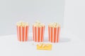 Three paper recyclable striped cups with popcorn