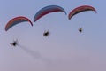 Three paramotors flying against the sky painted in the colors of a beautiful sunset Royalty Free Stock Photo
