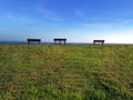 Three park benches looking out to sea Royalty Free Stock Photo