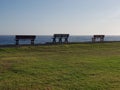 Three park benches looking out to sea Royalty Free Stock Photo