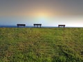 Three park benches looking out to sea Royalty Free Stock Photo