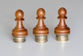 Three pawns chess pieces on columns of coins, symbolizing the equality of income