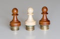 Three pawns chess pieces on columns of coins, symbolizing the equality of income